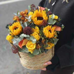 Композиция в сумке "Тональность" из подсолнухов, калл, ягод вибирнума, лимонных роз, скиммии и орхидеи в Красноармейске